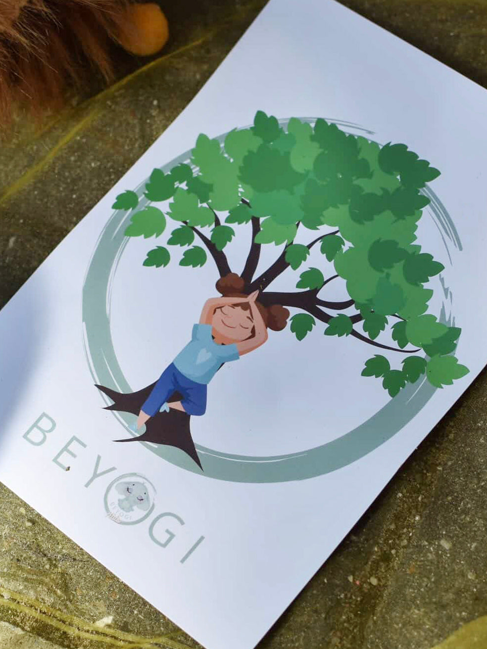 Illustration af en voksen og et barn i yogastilling under et grønt træ med BEYOGI-logo.